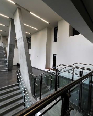 Dual stairway view of a Ferric guardrail with glass infill installation at Benedum Hall, Pittsburgh, PA.