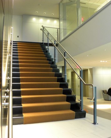 Upward view of Ferric guardrail with glass infill installation at Cooley Goodwin, MA.