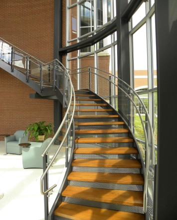Ferric curved guardrail with glass infill installation at Clare Rose Corp., NY.