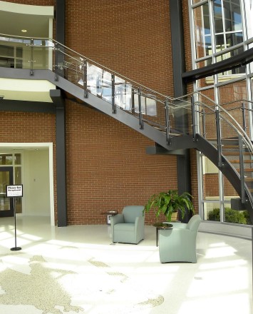 Ferric curved guardrail with glass infill installation at Clare Rose Corp., NY.