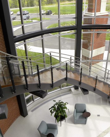 Ferric curved guardrail with glass infill installation at Clare Rose Corp., NY.