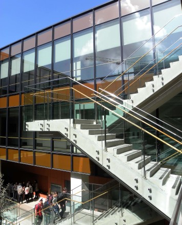 Outdoors side angled view at University of California San Diego, CA, Optik guardrail with clear glass and wood handrail