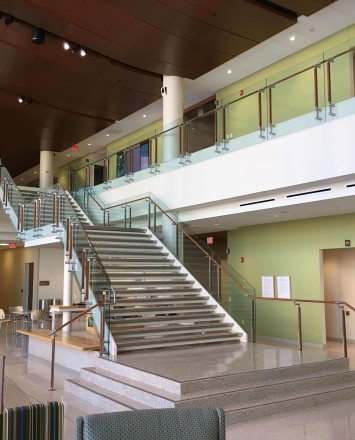 Atrium stair at University of Wisconsin School of Nursing, Kubit glass railing with wood top rail and posts.