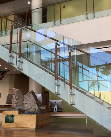 Atrium stair at University of Wisconsin School of Nursing, Kubit glass railing with wood top rail and posts.