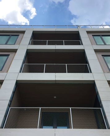 Circum round guardrail with stainless steel infill mesh attached via cable infill rail at Monroe Condominiums, NJ.