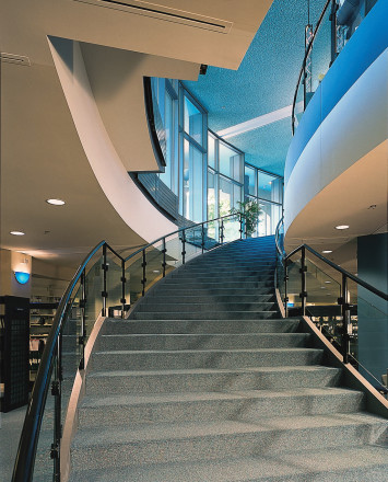 Upward angle of curved Hewi guardrail with clear glass infill at the Kalamazoo Public Library, MI.