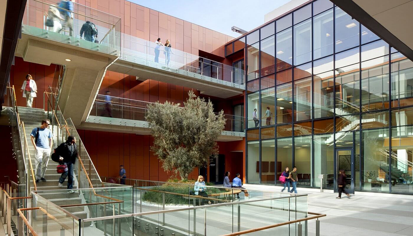 Outdoors side angled view at University of California San Diego, CA, Optik guardrail with clear glass and wood handrail