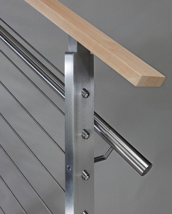 Closeup of stainless steel metal infill railing connection with wooden top rail