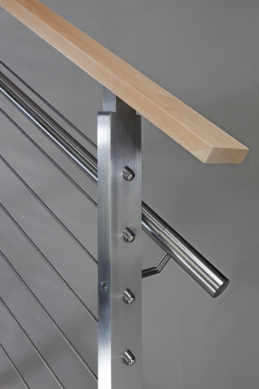 Closeup of stainless steel metal infill railing connection with wooden top rail