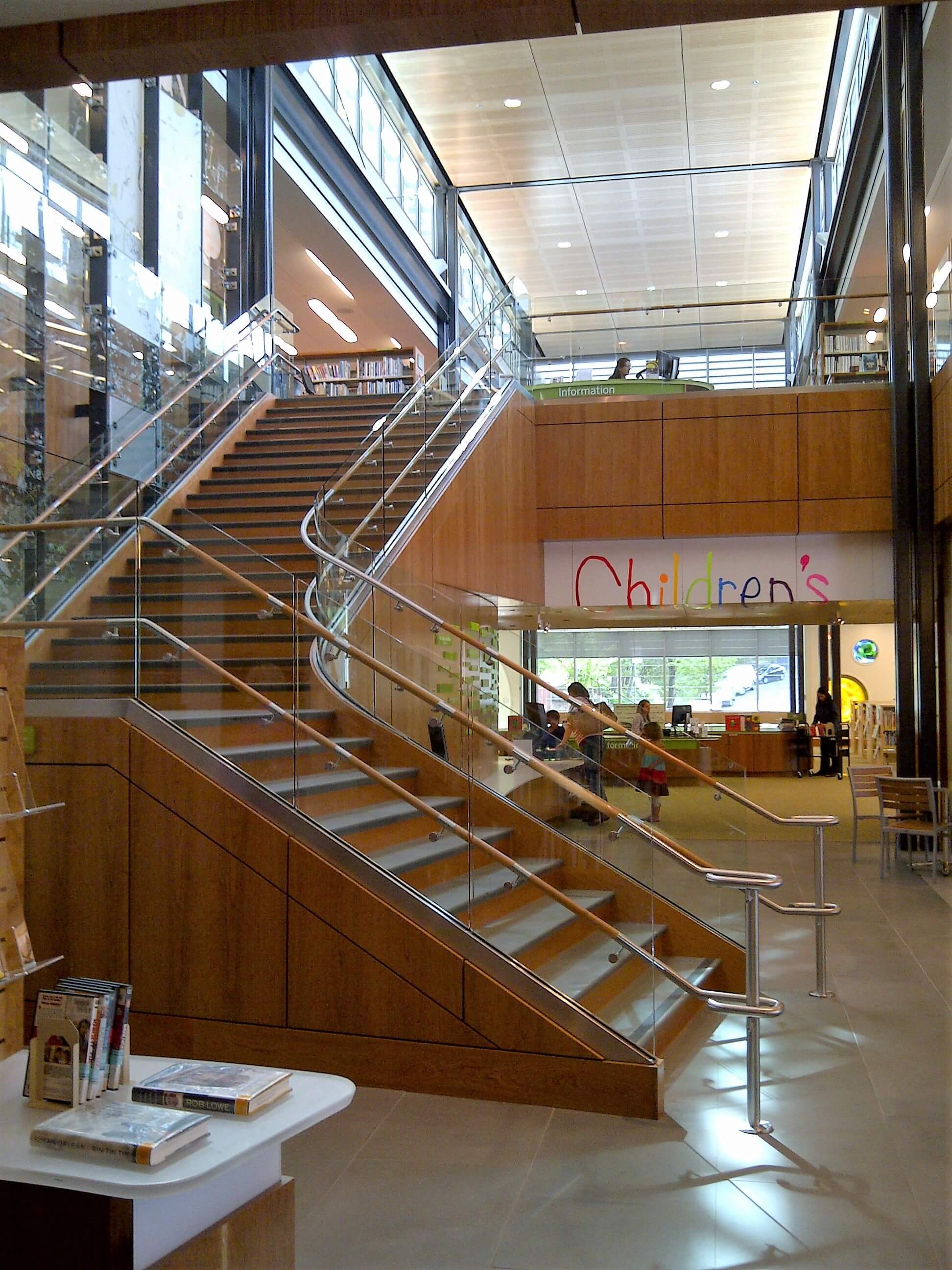 Upward view of open stairwell at Los Gatos Library, Optik Shoe with wood handrails and custom shelf