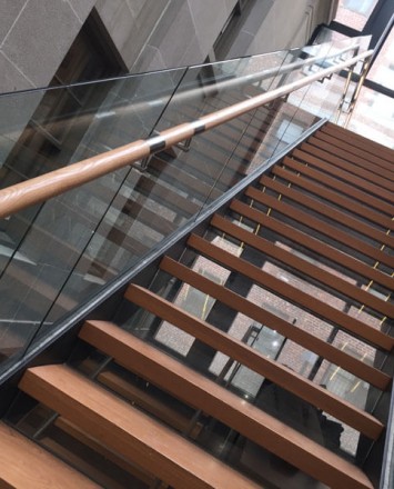 Glass staircase baffles with wooden handrail