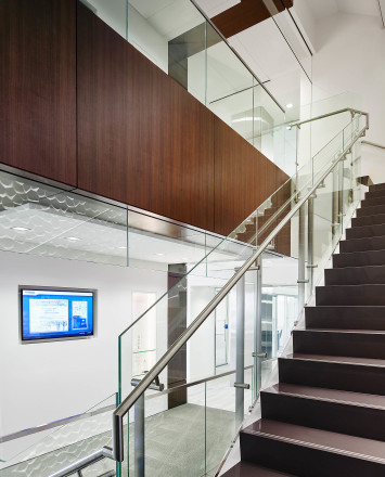 Upward view of white & wood staircase Smoke baffle system with Konic railing system